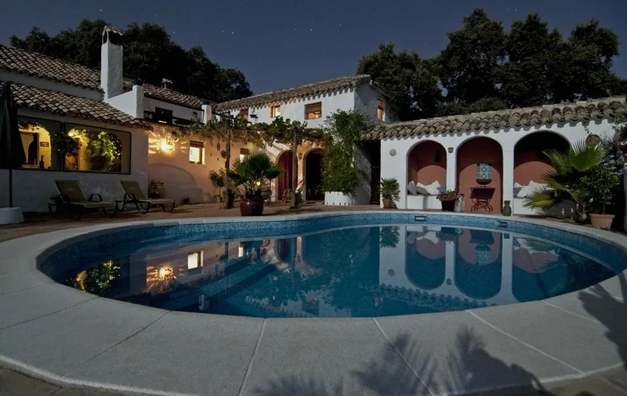 Ein Haus im spanischen Stil mit Ziegeldach neben einem Pool